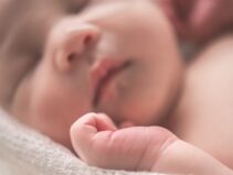 sleeping baby on white textile